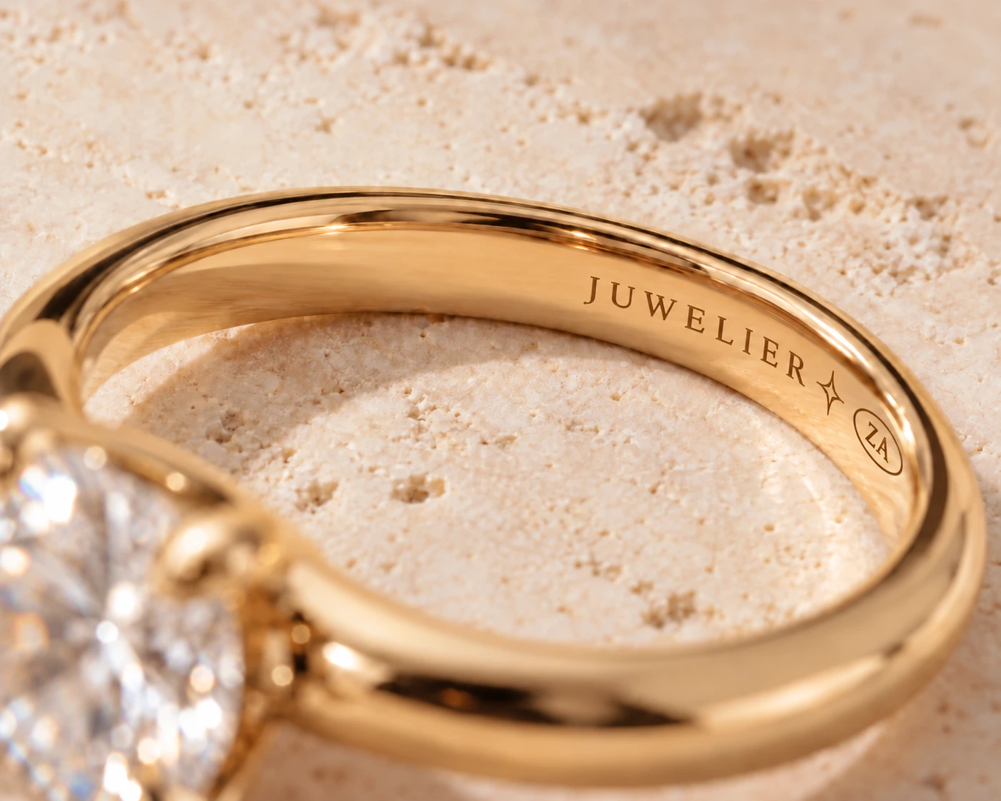Concept image of JUWELIER and a four-point facet mark laser-engraved inside a gold ring band
